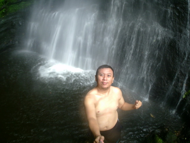 Berbicara destinasi wisata air terjun Malalak Agam Sumatera Barat, tak ada salahnya melihat air terjun Batang Marambuang. Sebuah destinasi alam dengan pesona indahnya yang masih asri dan menarik untuk dikunjungi. Malalak sendiri merupakan salah satu kecamatan yang berada di dalam wilayah kabupaten Agam Provinsi Sumatera Barat. Selain itu Kecamatan ini juga merupakan sebuah kecamatan termuda yang ada di kabupaten ini. Meskipun begitu wilayah kecamatan ini mempunyai segudang kapasitas sebagai destinasi wisata yang menarik. Kapasitas destinasi wisata menarik juga ditandai dengan adanya potensi wisata alam air. Banyaknya air terjun yang melimpah di kecamatan ini kerap juga dimanfaatkan oleh masyarakat lokal sebagai Pembangkit Listrik Tenaga Air Mini. Ada banyak potensi dengan lebih kurang 17 destinasi wisata air dimana dari sebagian itu semua di kelola swadaya oleh masyarakat lokal. Salah satu yang menarik dan saya kunjungi adalah Air Terjun Batang Marambuang dengan pesona dan adanya pedang menancap ke bumi. Mengunjungi Air Terjun Malalak, Air Terjun Batang Marambuang. Berangkat dari kota Pekanbaru menggunakan sepeda motor bersama 2 orang teman dari Komunitas Kaskus Regional Riau Raya langsung menuju kampung saya yang notabene masih disatu kabupaten dengan Malalak, yaitu di Kecamatan Matur. Dari kampung saya sendiri untuk bisa sampai di Kecamatan Malalak berjarak 30 menit dengan memakai sepeda motor. Pada awalnya kami memang merencanakan untuk ke destinasi wisata Air Terjun Langkuik Tamiang di Malalak, tetapi setiba di lokasi ternyata sedang ditutup karena ada musibah banjir bandang yang memakan korban. Karena di luar rencana, kami pun menelusuru jalan sepanjang di daerah ini. Setelah banyak melewati destinasi lokal, saya akhirnya melihat sebuah spanduk yang menunjukan sebuah tempat wisata alam dengan background gerojokan dan sebuah tugu pisau menancap serta bertuliskan Air Terjun Batang Marambuang. Kami pun langsung menelusuri dan menuju lokasi wisata tersebut. Sebuah pedang menancap Selang beberapa waktu kami mengikuti penunjuk jalan di lokasi tersebut, tibalah kami di pemberhentian terakhir yang merupakan rumah warga lokal terakhir dari sisi jalan. Karena tidak ada lagi jalur untuk kendaraan kami pun bertanya dengan ibu - ibu yang sedang berada di lokasi. Dari bertanya tersebut, ibu itu menganjurkan untuk meletakkan motor di kediamannya dan lanjut menelusuri dengan berjalan kaki. Agar lebih mudah, ibu memanggil seorang anak remaja yang kebetulan juga ada di dekat rumah ibu, dimana remaja yang bernama Buyung itu menjadi penuntun jalan kami menuju tempat yang kami tuju. Jalan kami dimulai dengan melewati indahnya hijau area persawahan yang kemudian dilanjutkan dengan adanya tanjakan naik terus masuk ke dalam hutan. Untuk bisa sampai di destinasi yang kami inginkan membutuhkan waktu kurang 30 menit, dimana sebelum sampai di titik akhir kita bisa melihat sebuah air terjun kecilnya. Waktu di jam tangan saya sudah menunjukan perjalan sekitar 20 menit, dan tak lama setelah itu saya mulai mendengar riuh suara khas destinasi air terjun. Dari kejauhan terlihat air terjun kecil yang sudah dibicarakan sebelumnya dengan debit air yang tidak terlalu banyak. Kami pun terus melanjutkan perjalanan menuju destinasi yang memang kami ingin tuju. Dengan semangat bertubi-tubi jalan dan menyebrangi sungai-sungai kecil serta mendaki tanjakan bebatuan finally !!!. Tampak sebuah pedang atau bisa dikatakan sebuah pisau yang menancap di tanah. Di belakang pedang tersebut namapak air terjun Malalak yang kami ingin lihat dari tadi, Air Terjun Batang Marambuang. Penat seketika hilang, yang lalu membuat saya dan teman - teman menyiapkan kamera untuk berswafoto. Ingin tau, saya pun bertanya dengan si Buyung tour guide kami, tentang keberadaan tugu pisau yang menancap ini. Kenapa dan siapakah yang mendirikannya. Dari pertanyaan tersebut, remaja itu mengatakan jika lokasi destinasi alam ini sering atau kerap dijadikan sebagai lokasi latihan para Kopassus. Karena seperti sudah sebagai rumah sendiri, tim Kopassus tersebut lalu membuat prasasti atau monumen pisau ini pada ekspedisi Bukit Barisan ditahun 2011 yang lalu. Sehingga memang tempat ini selalu dijaga dan digunakan ditiap-tiap acara latihan Koppasus. Puas bertanya, kegiatan selanjutnya adalah menikmati indahnya pesona air terjun Malalak, Air Terjun Batang Marambuang ini. Dengan menggunakan kostum mandi yang sudah kami persiapkan sebelumnya, kami langsung mencoba menikmatinya. Dengan satu kaki yang baru masuk di aliran airnya, kami sedikit terkejut dengan dinginnya. Dengan tinggi sekitar 75 meter, kondisinya lumayan deras. Disekitar aliran juga banyak bebatuan, sehingga memang membuat saya dan teman-teman sedikit berhati-hati. Tentu saja di tengah dengan musimnya kabut asap di Sumatera, saya bisa menikmati dan merasakan alam di destinasi ini. Tak ingin cepat atau segera beranjak dari indahnya destinasi wisata ini. Air terjun Batang Marambuang yang kami nikmati ini nyatanya memang indah, bersih, asri dan memberi kenyaman sendiri dengan suara - suara burung dan lantunan nada jatuhnya air yang membuat pilihan kami kali ini tak mengecewakan. Walaupun kenyamanan kami sedikit terganggu dengan tak lama turun rintik hujan yang tentu saja membuat kami harus menyudahi mandi-mandi yang kami lakukan. Kami pun bergegas dan beranjak pulang dari pengalaman yang menarik ini. Oh iya sampai lupa, untuk menggunakan jasa tour guide bayarannya terserah dan seikhlasnya. Tak lupa dari beberapa permintaan warga untuk membantu menyebarkan destinasi wisata indah ini. Air Terjun Batang Marambuang, Alam elok yang indah mempesona yang menjadi bagian indahnya banyak air terjun Malalak.